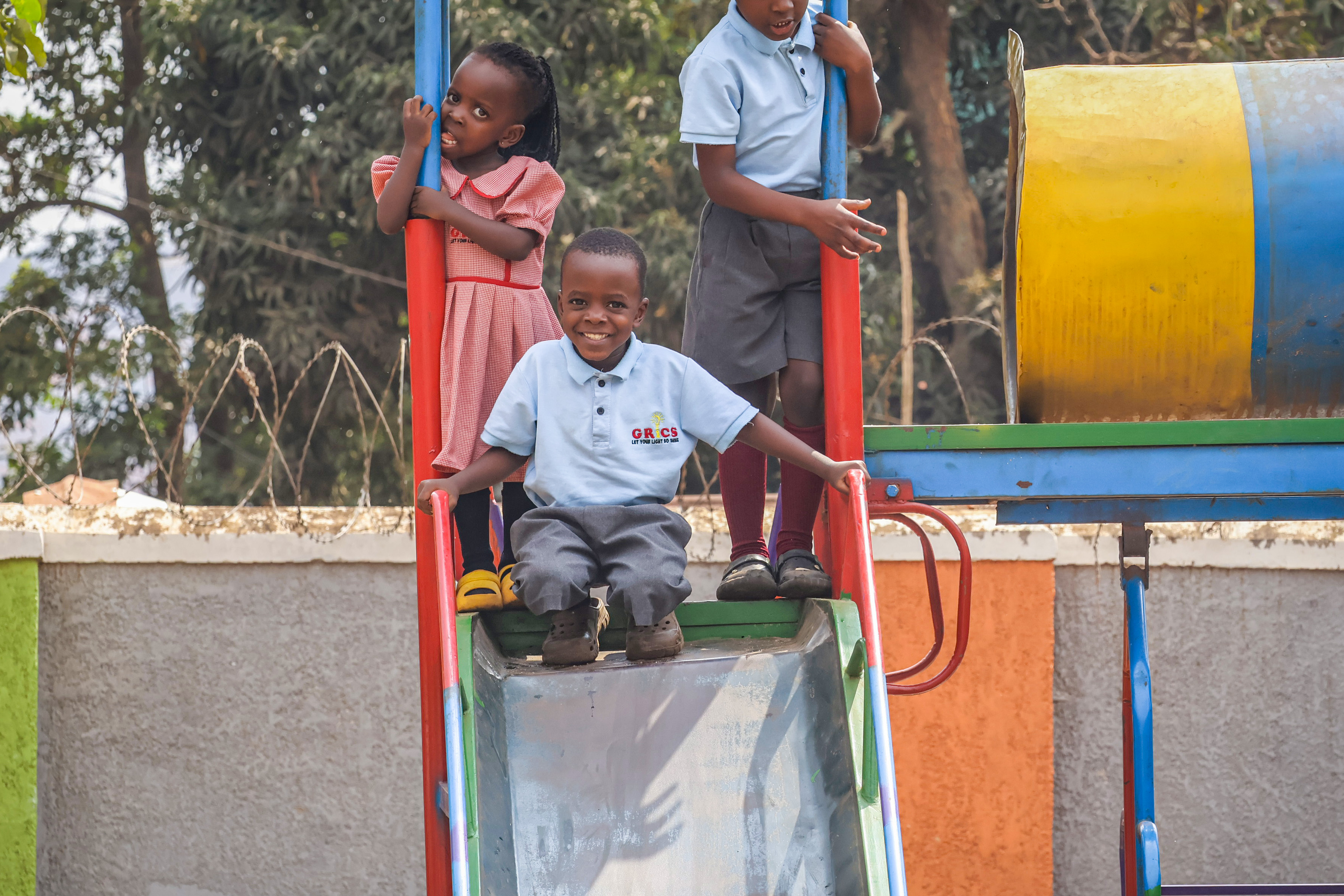 Three students playing together on the playground climbing frame